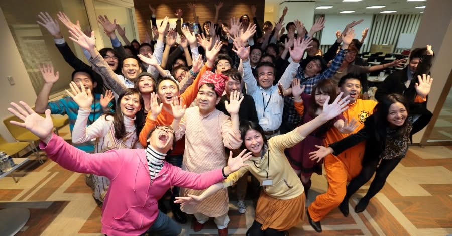 TheWaveコミュニティの仲間たちが笑顔で手を広げる集合写真